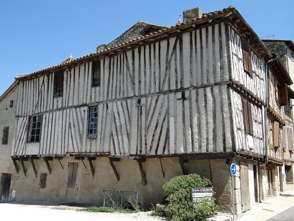 Maisons à pans de bois en encorbellement rue Sully à Nérac, avec colombages apparents et nombreuses petites fenêtres.